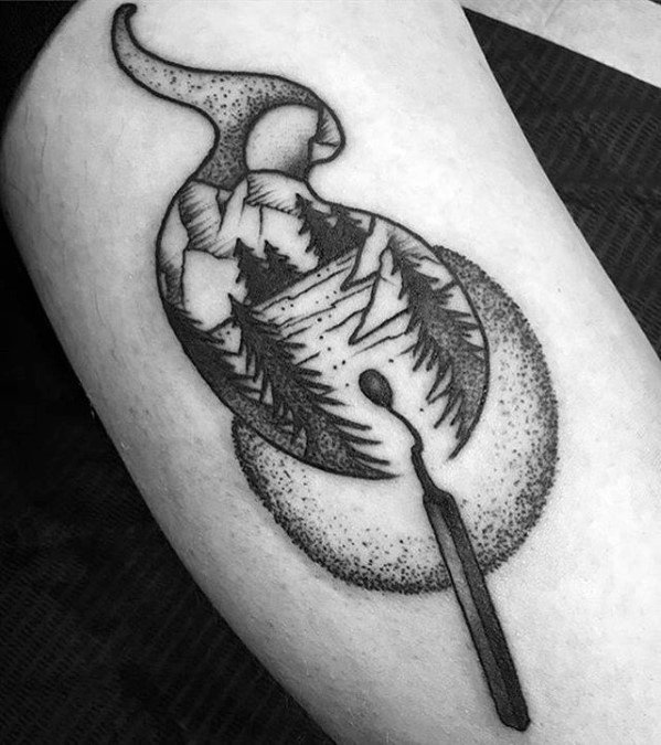 Black and grey tattoo of a matchstick with smoke forming a mountain and forest scene, symbolizing inner fire, nature, and escape.
