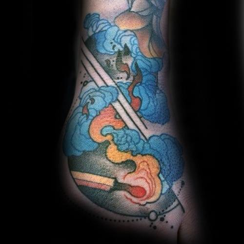 Abstract foot tattoo with vibrant blue, orange, and yellow swirls featuring a circular design and a matchstick.
