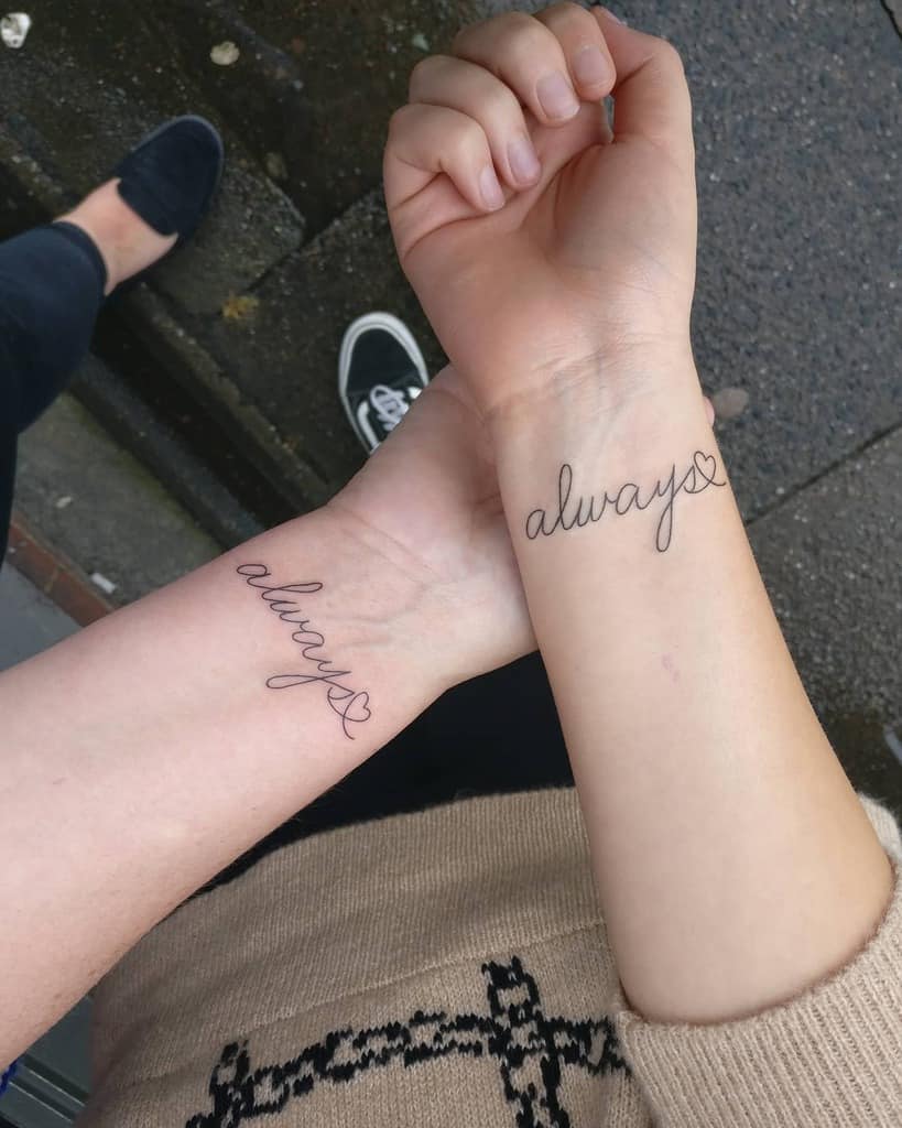 Two wrists with matching "always" tattoos and small heart symbols