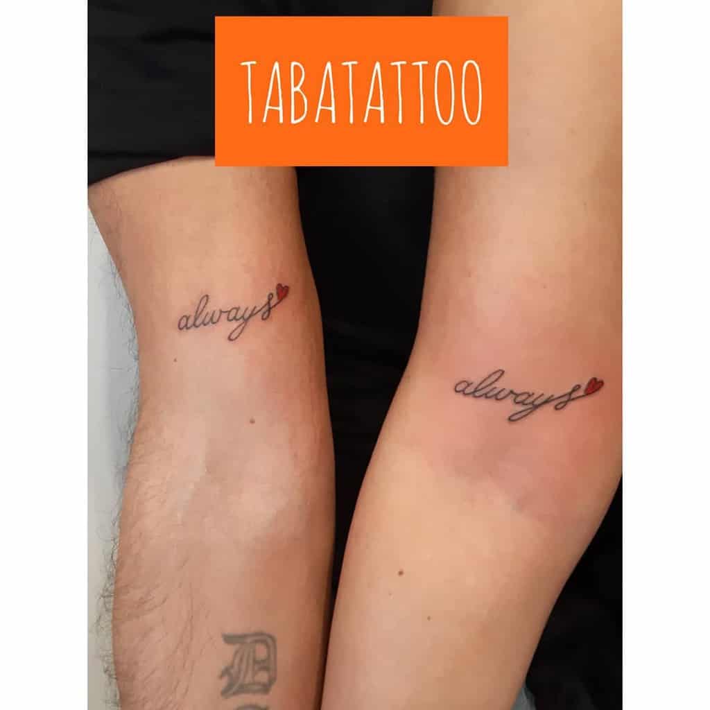 Matching tattoos saying "always" with a red heart above two elbows