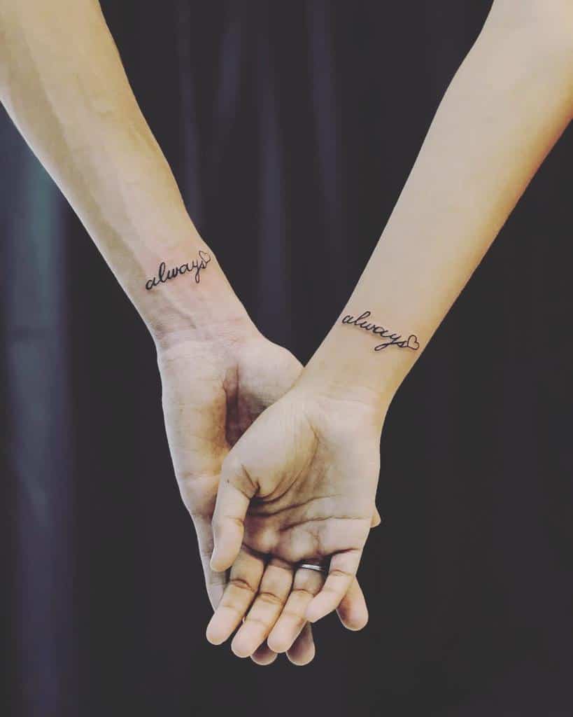 Two hands interlocked, each wrist with a tattoo of the word "always" in cursive