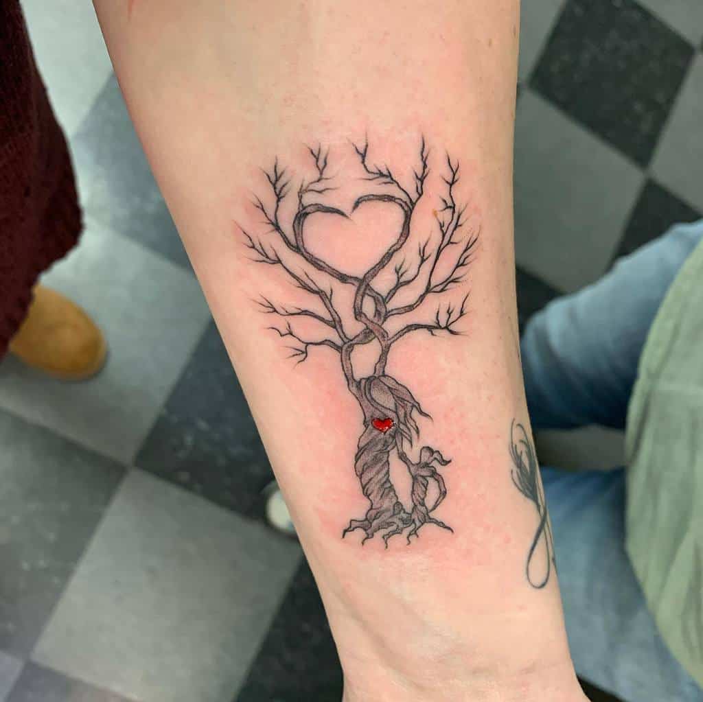 A symbolic mother-daughter tattoo featuring intertwined trees forming a heart, representing deep-rooted love