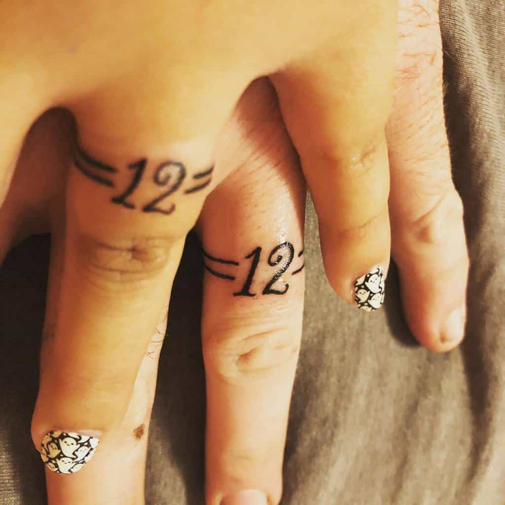 Matching wedding ring tattoos featuring the number "12" enclosed by equal signs, symbolizing a special connection