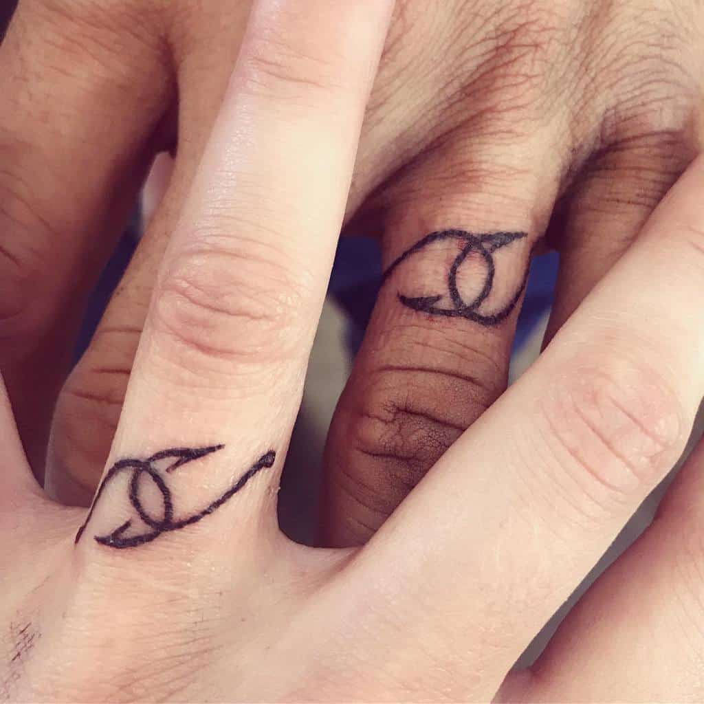 Matching wedding ring tattoos featuring intertwined loops, symbolizing connection, unity, or love