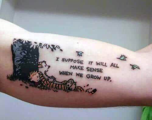 Tattoo of Calvin and Hobbes under a tree with the quote "I suppose it will all make sense when we grow up"