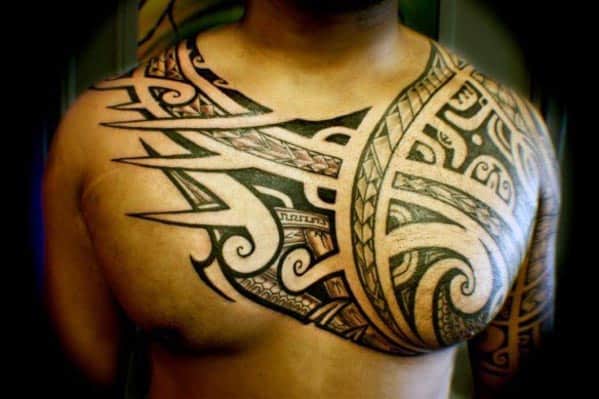 Man's chest and shoulder adorned with an intricate Polynesian tribal tattoo design