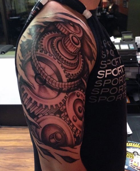 Tattooed shoulder showcasing detailed mechanical gears and clockwork design
