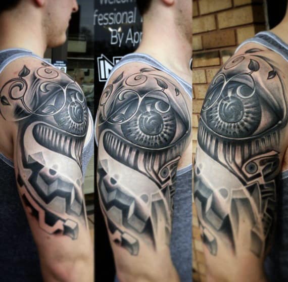 A man with an intricate black and gray mechanical-themed tattoo on his upper arm