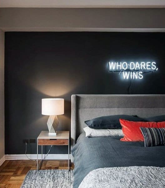 modern bedroom with who dares wins fluro sign 