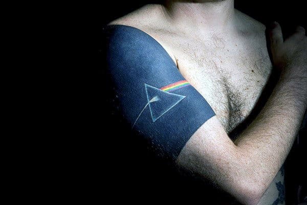 Close-up of a man's arm with a detailed Pink Floyd album cover tattoo