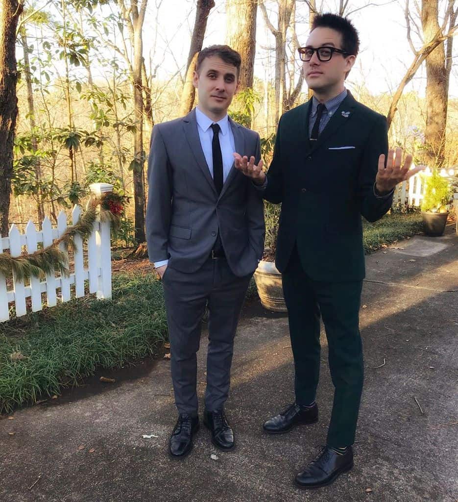 Two men outdoors wearing slim-fitting mod suits with thin neck ties