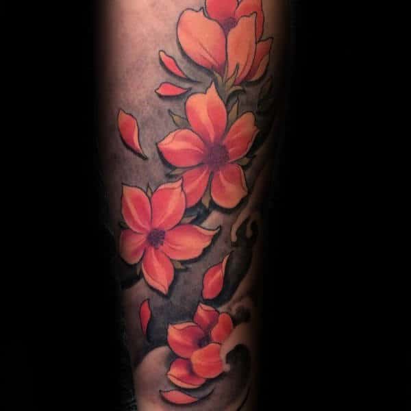 Forearm tattoo featuring vibrant orange cherry blossoms with detailed shading, falling petals, and a dark swirling background for contrast