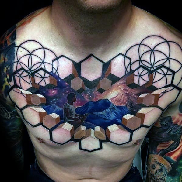 Vibrant chest tattoo featuring a geometric pattern blending into a cosmic scene with a meditative figure, 3D cubes, and intricate linework for a surreal design.