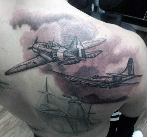 Back tattoo of two WWII airplanes flying above a ship, shaded in grayscale