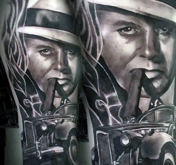 Al Capone tattoo sleeve featuring a black-and-white portrait of the gangster smoking a cigar, with vintage cars and smoke surrounding him, capturing the essence of his era.
