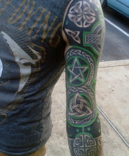 Detailed Celtic-themed sleeve tattoo with green and black designs