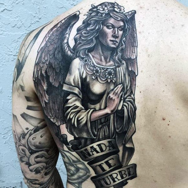 Angel tattoo with "Nada Te Turbe" text on a person's upper back and shoulder