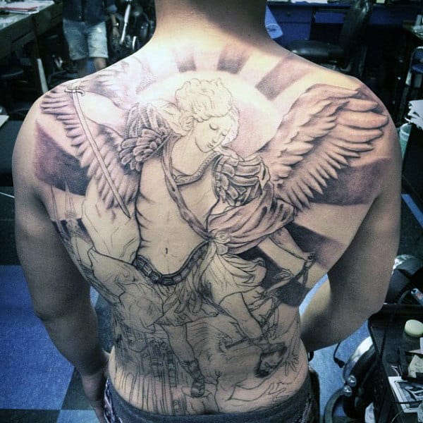 Full-back tattoo depicting an angel with wings and a spear, surrounded by rays of light.