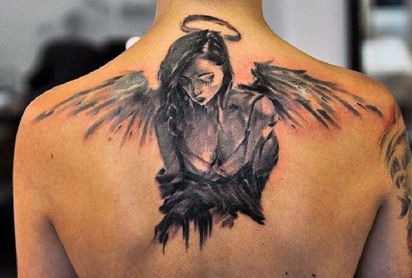 Tattoo of a dark-winged angel with a halo on a person's upper back