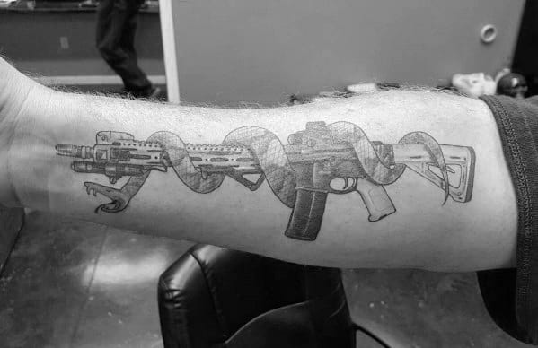 Black and grey AR-15 tattoo with a coiled snake wrapped around the rifle, symbolizing strength, defiance, and the right to bear arms.