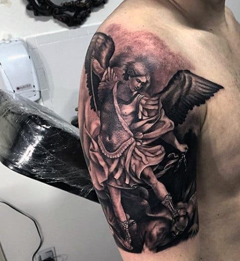 Intricate angel tattoo with wings and armor on a person's upper arm