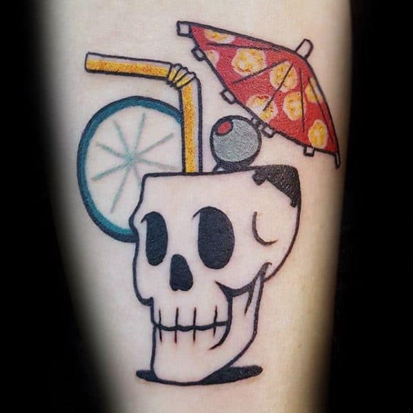 Bold tattoo of a skull-shaped tropical drink with a slice of lime, red cocktail umbrella, and straw, blending spooky and fun summer vibes.
