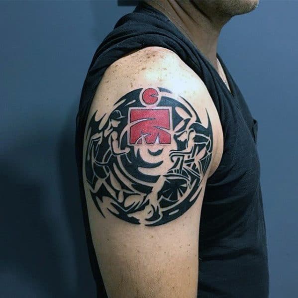 Ironman logo tattoo surrounded by intricate tribal designs, with bold black lines and a red Ironman symbol at the center.