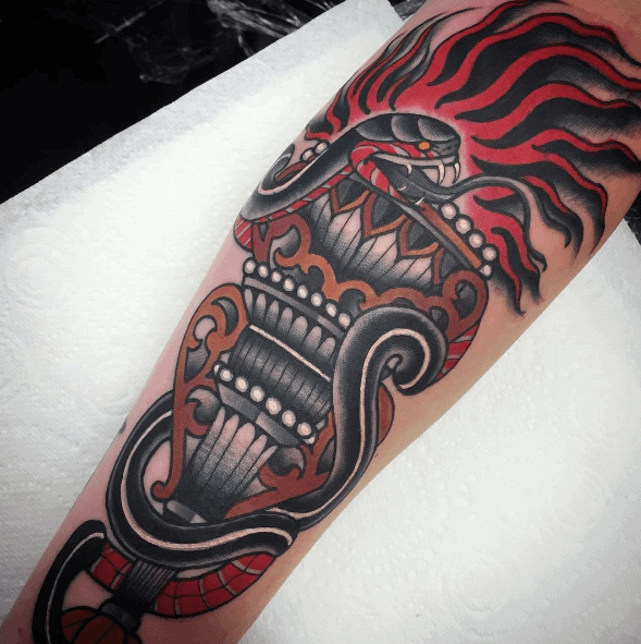 Traditional torch tattoo wrapped in a black and red snake, with fierce red flames and bold ornamental detailing on the handle.