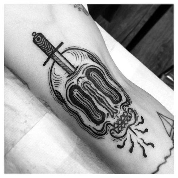 Blackwork tattoo of a stylized skull with a sword through the top and abstract lines and cracks around the mouth.