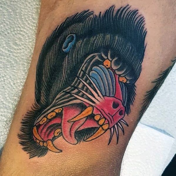 Neo-traditional baboon tattoo with bold outlines, vivid colors, and a fierce open-mouthed expression, creating a dynamic and striking leg design.