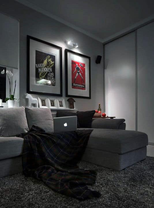 Cozy grey living room with movie posters, sectional sofa, and modern decor accents.