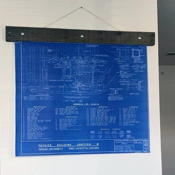 Framed blueprint of a building hanging on the wall with rustic wood accents.