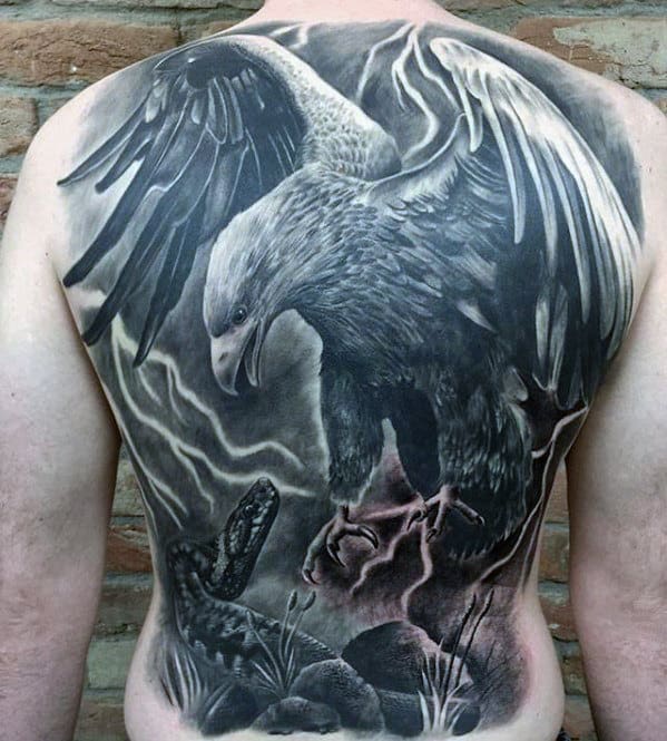 Back tattoo featuring a detailed eagle attacking a snake with lightning in the background