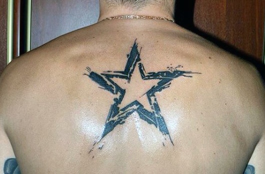 Tattoo of a distressed black star on a person's upper back