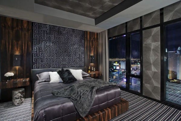 Modern high-rise bedroom with city view, dark accents, and geometric wall pattern.