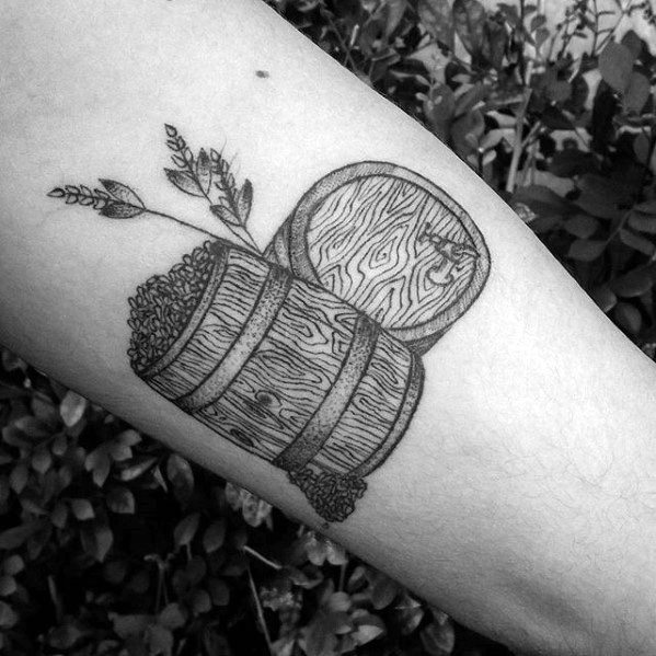 Black linework tattoo of two wooden barrels, one filled with hops or grain, accompanied by sprigs of barley for a rustic brewing-inspired design.