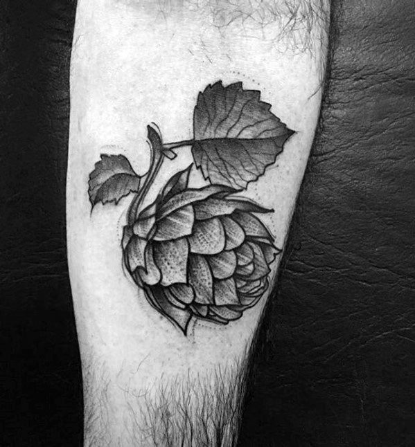 Black and gray tattoo of a detailed hop cone with textured shading and bold lines, paired with leaves for a classic botanical look.