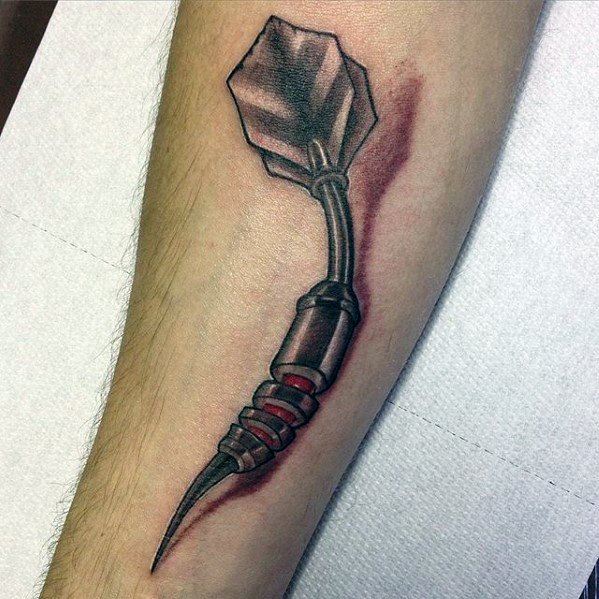 Forearm tattoo of a 3D-style bent dart with red shading around it, creating the illusion of it piercing deep into the skin.