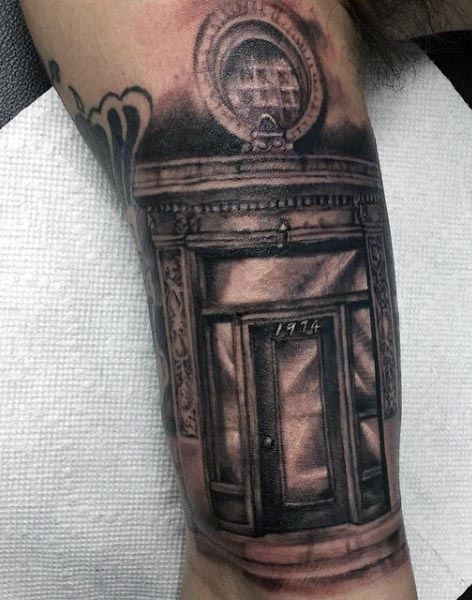 Black and grey realistic tattoo of an ornate doorway with intricate architectural details and the year '1974' inscribed on the door