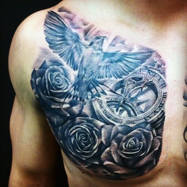 Tattoo of bird with outstretched wings, roses, and a clock on a man's chest