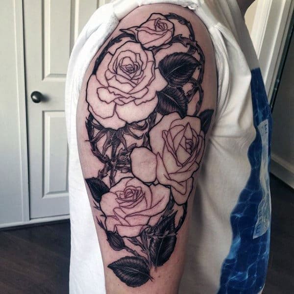 Arm tattoo featuring detailed roses and leaves in black and white