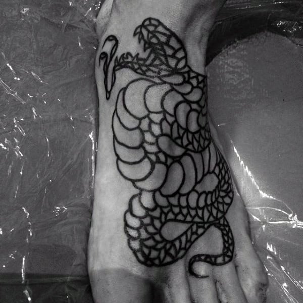 Black and white tattoo of a coiled, hissing snake with mouth open, inked on the top of a foot