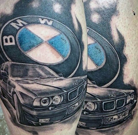 Realistic BMW E34 tattoo with bold shading, featuring a large BMW logo backdrop for a striking automotive-inspired design.