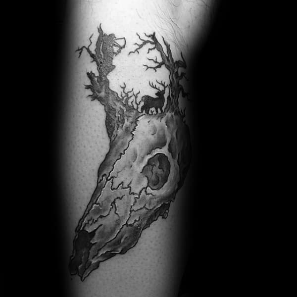 Black and grey tattoo of a weathered deer skull with antlers that morph into trees, with silhouettes of a deer and a bowhunter hidden within.