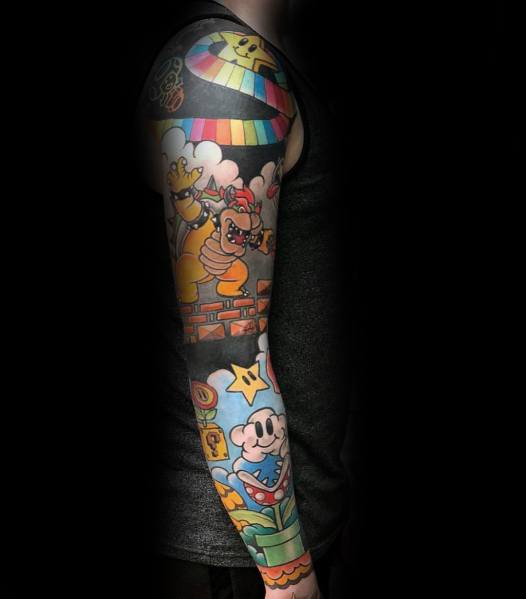Colorful Super Mario-themed sleeve tattoo featuring Bowser, Mario, and classic elements like stars and bricks, creating a vibrant gaming-inspired design.