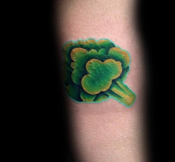 Small vibrant broccoli tattoo on the forearm, featuring rich green tones, smooth shading, and bold outlines for a simple yet eye-catching design.