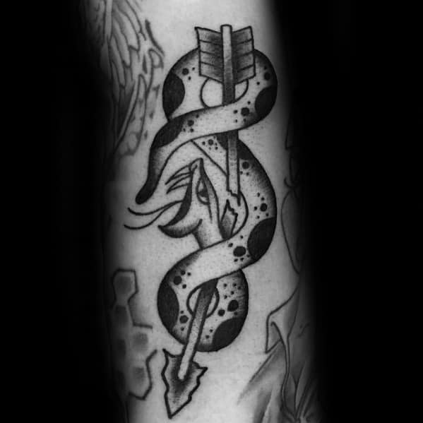 Black and grey tattoo of a broken arrow piercing through a coiled snake, blending traditional and neo-traditional elements with bold shading.