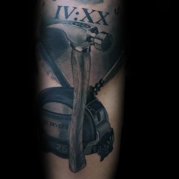 Realistic black and gray tattoo of a hammer, crossed tools, and a tool belt, with Roman numerals, symbolizing craftsmanship, dedication, and hard work.