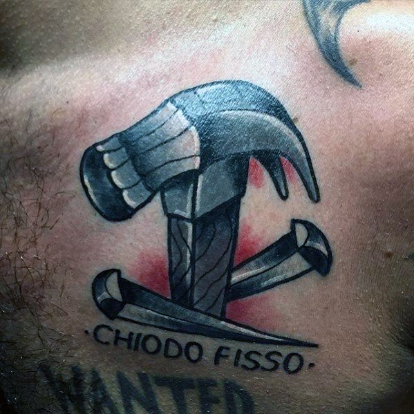 Tattoo of a hammer driving nails with the phrase "Chiodo Fisso," symbolizing determination, persistence, and a passion for craftsmanship.