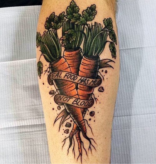 Bold carrot heart tattoo featuring three carrots forming an anatomical heart, wrapped in a ribbon with the phrase “Real Food Has No Blood” for a powerful design.